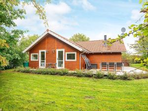 ein kleines Haus mit einem grünen Hof davor in der Unterkunft Three-Bedroom Holiday home in Allingåbro 3 in Nørager