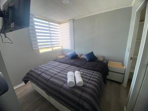 Un dormitorio con una cama con calcetines blancos. en Amplio y acogedor departamento, en Curicó