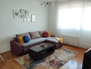 een woonkamer met een bank en een salontafel bij Apartman TOM Bijeljina in Bijeljina