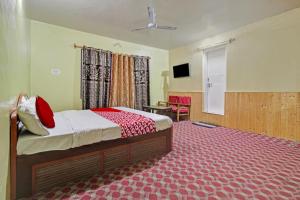 a bedroom with a bed and a table and a television at Hotel Ab-i-Hayat in Srinagar