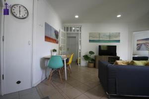a living room with a couch and a clock on the wall at Lisbon South Apartment in Lisbon