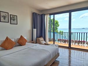 a bedroom with a bed with a view of the ocean at Lipe Sunrise Beach House in Ko Lipe