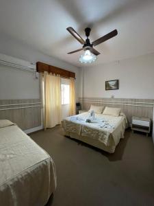 a bedroom with two beds and a ceiling fan at Hotel Dora in Termas de Río Hondo +18 photos
