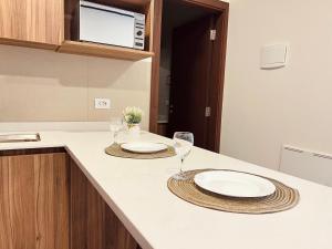 a kitchen with two plates and wine glasses on a counter at Apartamento de Lujo a Pasos de la Av. América in Cochabamba