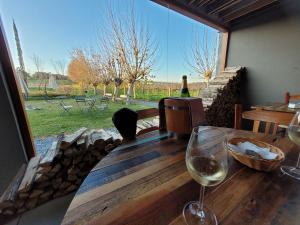 einen Tisch mit einem Glas Wein und einem Fenster in der Unterkunft Nosso Ap em Bento in Bento Gonçalves