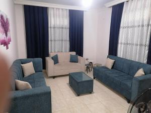 Yaso Roof & Apartments في عمّان: غرفة معيشة بها كنب ازرق وكرسي