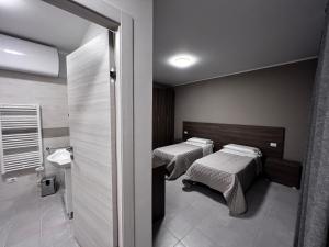 a room with two beds and a bathroom at Bella Napoli albergo Chiari in Chiari