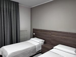 1 dormitorio con 2 camas y ventana en Bella Napoli albergo Chiari, en Chiari