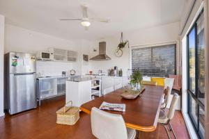 a kitchen with a wooden table and a dining room at Treetops Haven Venus Bay in Venus Bay