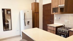 a kitchen with a white refrigerator and a stove at Apartamento de Lujo a Pasos de la Av. América in Cochabamba