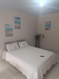 a white bedroom with a bed with white sheets at Pousada 12 Ilhas in Pontal do Paraná