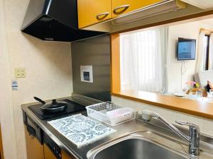une cuisine avec un évier et un plan de travail dans l'établissement JOY IN民宿两站关西机场一站奥莱，整租，提供机场接送服务,步行可达便利店、免税购物中心、药妆店, à Izumi-Sano