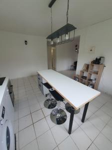 フォール・ド・フランスにあるUn Souffle de Vacancesの白いテーブル付きのキッチンが備わる客室です。