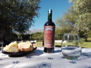 a bottle of wine and a plate of bread on a table at Casa del viñedo in Villa Las Rosas