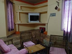a living room with two chairs and a tv at Paradise Castle Villa in Auroville