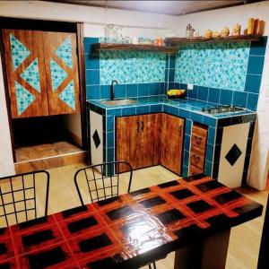 cocina con mesa y pared de azulejos azules en San Joaquín Hospedaje Campestre, en Belén de Umbría