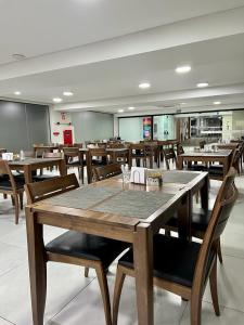 a dining room with wooden tables and chairs at Asa Hotel in Piracicaba