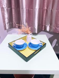 a tray with two cups and saucers on a table at A private Large master room with en-suite in Auckland