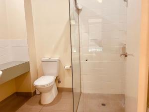 uma casa de banho com um WC e uma cabina de duche em vidro. em Mary MacKillop Heritage Centre em Melbourne