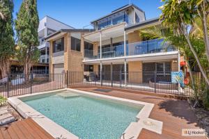 an apartment building with a swimming pool in front of a house at Kingscliff Ocean Vista in Kingscliff