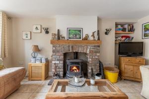 a living room with a fireplace and a couch at Priest Bridge Cottage in Bryansford