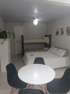 a room with a bed and a table and chairs at Pousada 12 Ilhas in Pontal do Paraná