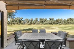a patio with a table and chairs and a golf course at Luxurious fairway condo resort country club in Palm Desert
