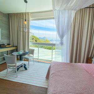a bedroom with a bed and a table and chairs at Rio Holiday Boutique Hotel in Niterói