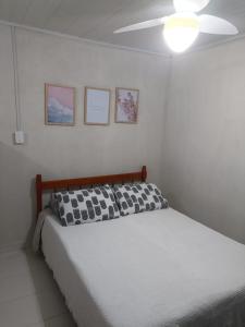 a bedroom with a bed with a ceiling fan at Pousada 12 Ilhas in Pontal do Paraná
