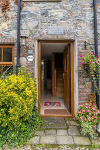 einen Eingang zu einem Steingebäude mit einer Tür in der Unterkunft Priest Bridge Cottage in Bryansford
