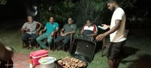 eine Gruppe von Menschen, die um einen Grill herum sitzen in der Unterkunft Nature View in Batticaloa