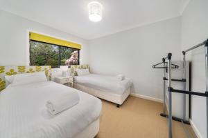 a bedroom with two beds and a window at Lynwood Gardens in Blackheath