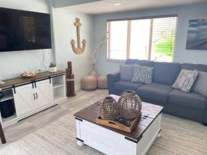 a living room with a blue couch and a tv at key Deer Retreat/direct gulf access/hot tub in Big Pine Key