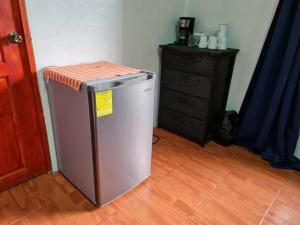 a small refrigerator with an orange top next to a dresser at Osa Corcovado Lodge in Drake