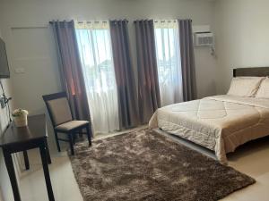 1 dormitorio con 1 cama, 1 mesa y 1 silla en Camella Manors Condo, IBIZA Bldg., en Bacolod