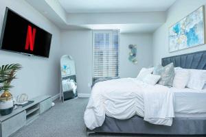 a bedroom with a large bed with a tv on the wall at The Bleu Oasis in Atlanta