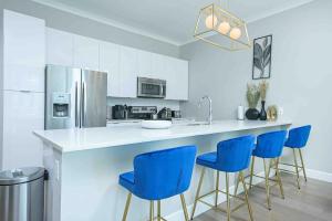 a kitchen with a counter with blue bar stools at The Bleu Oasis in Atlanta