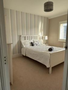 a bedroom with a bed with white sheets and pillows at LN Host in Hardingstone