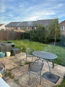 a patio with a table and chairs in a yard at LN Host in Hardingstone