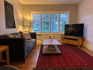 a living room with a couch and a tv at LN Host in Hardingstone