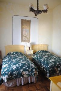 a bedroom with two beds and a table with a lamp at Hostal La Chacarilla in Copacabana
