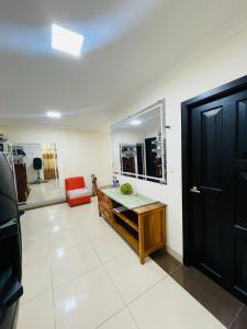 W łazience znajduje się biurko, lustro i czarne drzwi. w obiekcie Confortable Apartamento w Puerto Francisco de Orellana