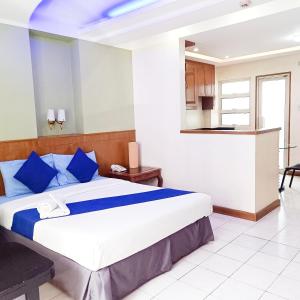 馬尼拉的住宿－Alley 8 Makati，一间卧室配有一张带蓝色枕头的大床