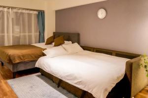 東京にあるNew Design Apartment in Shinjuku Kabukicho! 3 mins stationのベッド2台、壁掛け時計付きの客室です。