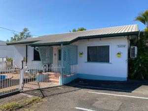 ein weißes Haus mit einem Tor davor in der Unterkunft Central Point Motel in Mount Isa