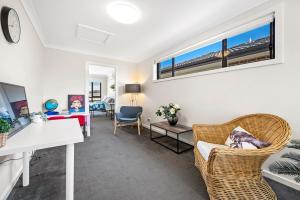 a living room with a couch and a table and chairs at 8Beds l 4 Suites with Office l Austral5 in Austral