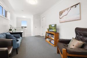 a living room with two couches and a tv at 8 Beds l 4 Suites with Office l Austral3 in Austral