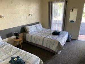 1 dormitorio con 2 camas y ventana en Central Point Motel, en Mount Isa