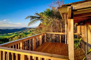 a wooden deck with a view of the mountains at Te Tiro Accommodation in Waitomo Caves