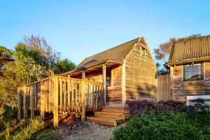 a wooden cabin with a deck and a house at Te Tiro Accommodation in Waitomo Caves